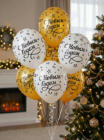 Букет из золотых и белых латексных шаров с черной надписью С Новым Годом и звездами на фоне елки.