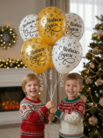 Букет из золотых и белых латексных шаров с черной надписью С Новым Годом и звездами на фоне елки.