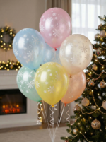 Набор воздушных шаров пастельных цветов с белым принтом снежинок на фоне новогодней елки.