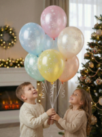 Набор воздушных шаров пастельных цветов с белым принтом снежинок на фоне новогодней елки.