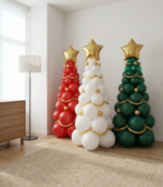 Три напольные елки из воздушных шаров красного белого и зеленого цвета с золотой звездой и гирляндами в интерьере